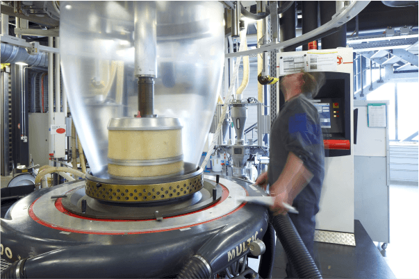 Technician performing maintenance on film blowing machine